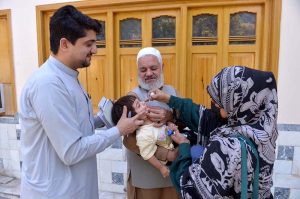 A health worker administers a polio vaccine to a child during a door-to-door vaccination campaign in at Zaryab colony faqirabad area