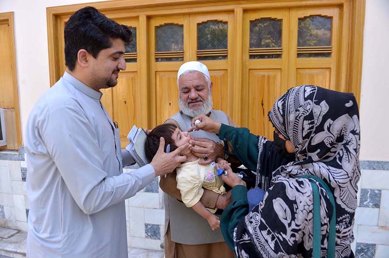 A health worker administers a polio vaccine to a child during a door-to-door vaccination campaign in at Zaryab colony faqirabad area