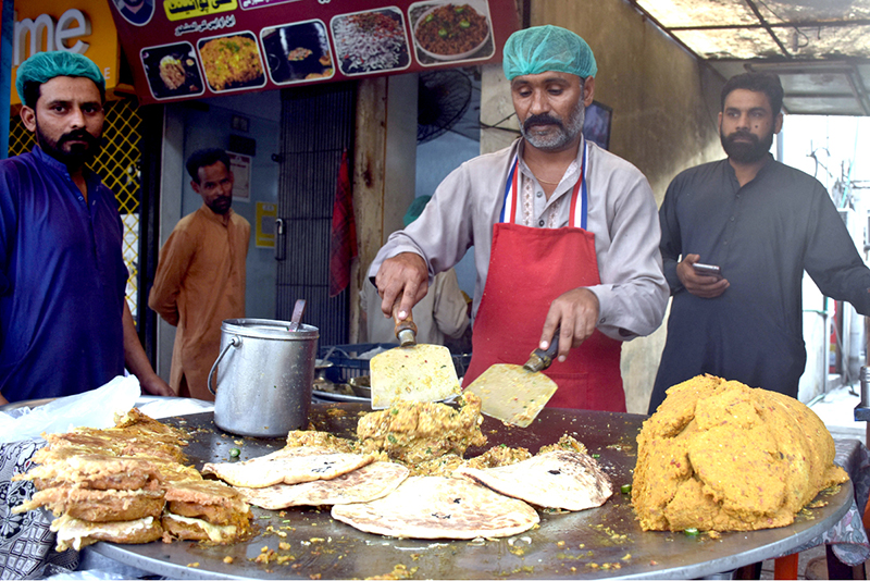 A street chef prepares tempting roll paratha at a roadside stall on Ferozepur Road in the city