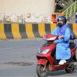 A woman on her way on electric scooty, nowadays a comfortable ride for women