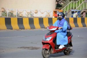 A woman on her way on electric scooty, nowadays a comfortable ride for women