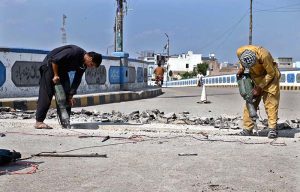 Labourers busy in repair work on the Railway over bridge Road.