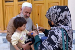 A health worker administers a polio vaccine to a child during a door-to-door vaccination campaign in at Zaryab colony faqirabad area