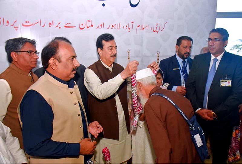 Chairman Senate Yousuf Raza Gilani is seen offing intending Hajj pilgrims with floral garlands as they depart for Madinah