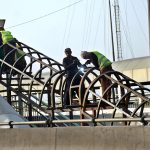 A welder welds an iron frame to install a shed at the metro station on Karnal Road in the provincial capital