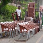 A vendor displaying and selling plastic chairs along the roadside
