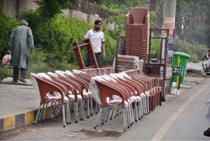 A vendor displaying and selling plastic chairs along the roadside