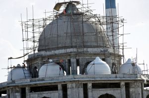 Labourers are busy in maintenance and restoration work at a historical shrine site.
