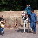 A girl enjoys horse ride at the historic Shahi Qila
