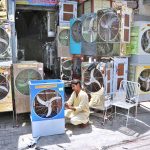 A worker is busy preparing a room cooler at his workplace as demand increases with the onset of the summer season