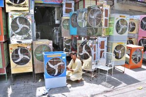 A worker is busy preparing a room cooler at his workplace as demand increases with the onset of the summer season