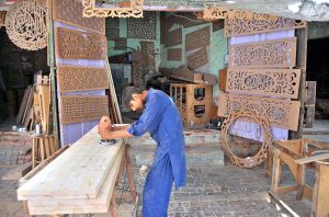 A worker is busy preparing a room cooler at his workplace as demand increases with the onset of the summer season