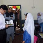 Sindh Chief Minister Syed Murad Ali Shah reviews a textbook and interacts with a girl student during a classroom visit at Government Boys Secondary School, Khayaban-e-Shujaat, Defence, on the occasion of inaugurating the province-wide anti-polio campaign