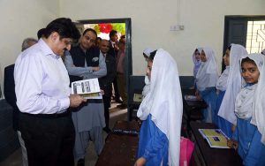 Sindh Chief Minister Syed Murad Ali Shah reviews a textbook and interacts with a girl student during a classroom visit at Government Boys Secondary School, Khayaban-e-Shujaat, Defence, on the occasion of inaugurating the province-wide anti-polio campaign