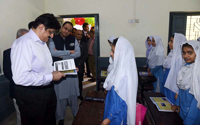 Sindh Chief Minister Syed Murad Ali Shah reviews a textbook and interacts with a girl student during a classroom visit at Government Boys Secondary School, Khayaban-e-Shujaat, Defence, on the occasion of inaugurating the province-wide anti-polio campaign
