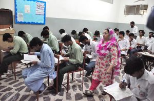 Intermediate students appear in examinations as invigilators monitor the examination process at a centre in the city.