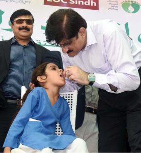 Sindh Chief Minister Syed Murad Ali Shah reviews a textbook and interacts with a girl student during a classroom visit at Government Boys Secondary School, Khayaban-e-Shujaat, Defence, on the occasion of inaugurating the province-wide anti-polio campaign