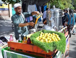 A vendor is preparing traditional summer drink to attract the customers at his setup