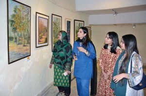 Visitor viewing the art exhibition titled “Yaadon ka Silsila” featuring works by renowned artist Dr Tooba Najam at the Punjab Council of Arts.
