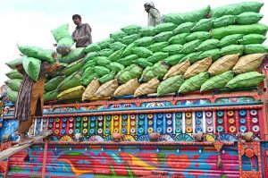 A labourer loading bags filled with vegetable on delivery truck at Vegetable Market