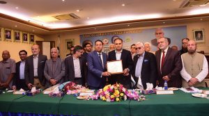 Office bearers of the Karachi Chamber of Commerce and Industry (KCCI) present a shield to Minister of State for Finance Bilal Azhar Kayani