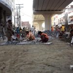 LDA workers engaged in fixing tuff tiles on the main road outside Data Darbar as part of ongoing maintenance work