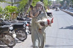 A motorcyclist on the way while covers his face with piece of cloth to protect himself from the scorching heat