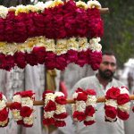 A vendor is waiting for customers to sell fresh flower hand garlands on the roadside in the provincial capital