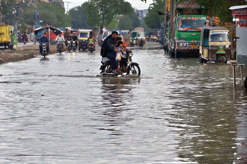 Motorcyclists passing through rain water accumulated on the road after rain that experienced the Provincial Capital