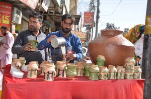 Vendor making Lassi (traditional yogurt) for customers which demand increased in hot weather at Meezan Chowk.