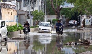 Motorcyclists passing through rain water accumulated on the road after rain that experienced the Provincial Capital