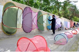 Man displaying mosquito nets on wall to attract the customers at Chman Phatak.