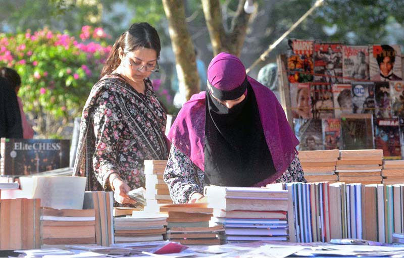 Women are busy selecting and purchasing old books from a stall at Frere Hall