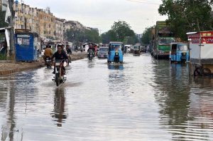 Motorcyclists passing through rain water accumulated on the road after rain that experienced the Provincial Capital