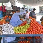 Vendor selling vegetable to customer at I/9 Bazaar in Federal Capital