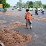 A CDA sanitary worker is busy cleaning Faisal Avenue after the late-night storm in the Federal Capital
