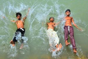 Youngsters jump into the Channel Mori Canal for a bath to get some relief from the hot weather in the city.