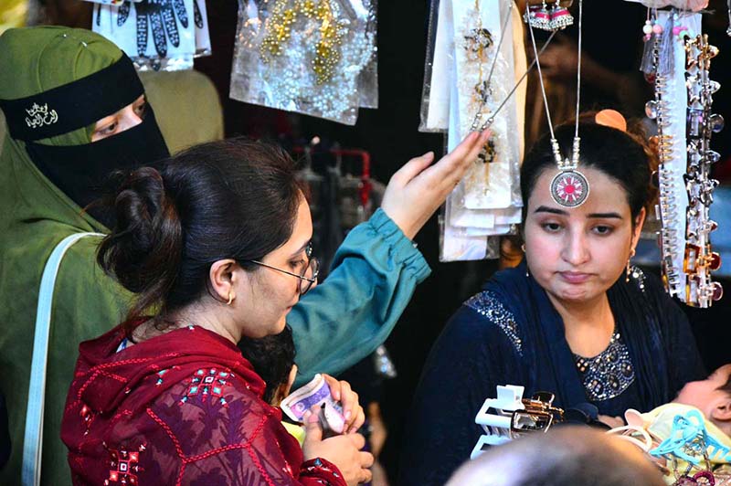 Women are busy selecting and purchasing artificial jewelry from vendor stall in preparation of Eid-ul-Azha at Resham Bazaar