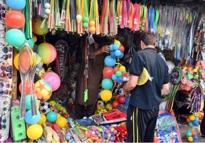 Women select and purchase sandals at H-9 Bazaar in the Federal Capital