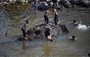 Children bathe in the water of Korang Nullah to cool off during intense hot weather, as soaring temperatures continue to affect daily life in the city