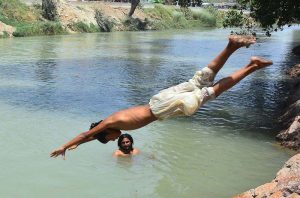 Youngsters jump into the Channel Mori Canal for a bath to get some relief from the hot weather in the city.