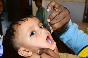 A health worker administers polio drops to a child during the ongoing anti-polio campaign in the city.