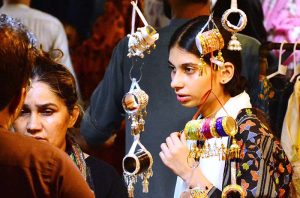 Women are busy selecting and purchasing artificial jewelry from vendor stall in preparation of Eid-ul-Azha at Resham Bazaar