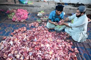 A butcher slaughters sacrificial animal on the first day of Eidul Azha at Madani Markaz Faizan e Madina SITE Area