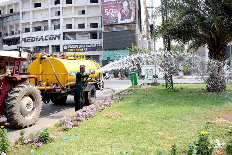 Parks and Horticulture Authority (PHA) workers are busy watering plants along the green belt to maintain the city’s greenery and beautification