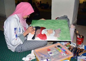 An art student busy in painting an art competition a painting competition, organized by the Punjab Arts Council Faisalabad