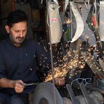 A blacksmith sharpens knives to be used for slaughtering sacrificial animals ahead of the upcoming Eid al-Adha at Chowk Noonarian Khuda Bakhsh Road