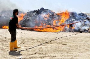 A customs official is busy burning contraband and hazardous goods organized by the Collectorate of Customs at the site area.