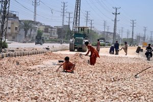 Labourers are busy in road expansion work during an ongoing development project being carried out by the district government at Autobahn Road