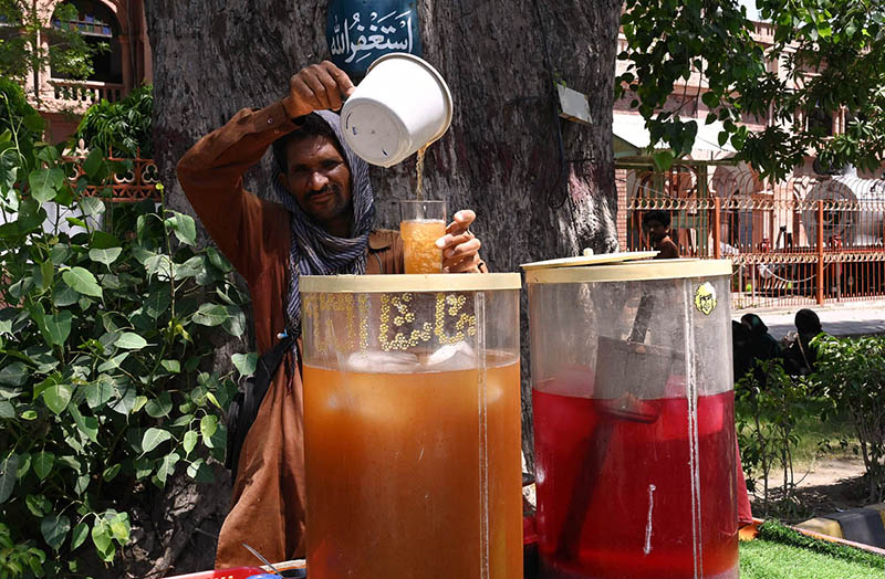 A vendor prepare and sells sweet drinks on the roadside during hot weather in the city